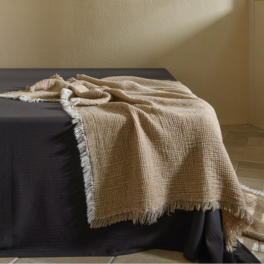 A woven cotton and linen fringed blanket