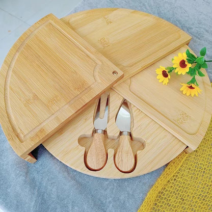 A bamboo and wood cheese board cheese board wooden round rotatable cutting board with drawer small bowl knife and fork set