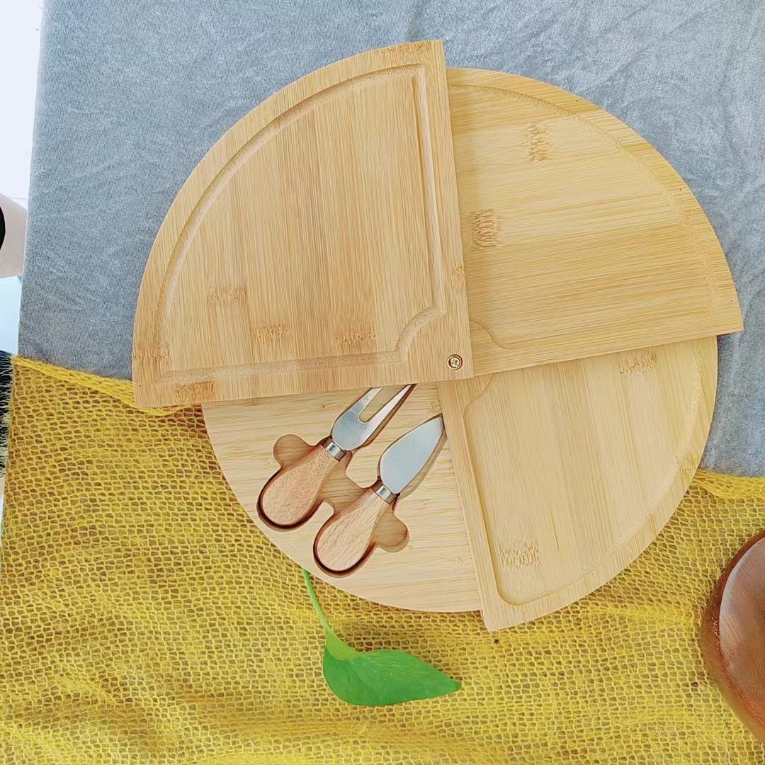 A bamboo and wood cheese board cheese board wooden round rotatable cutting board with drawer small bowl knife and fork set