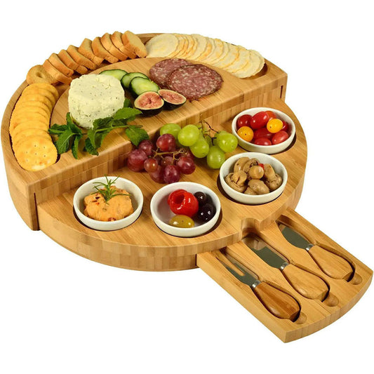 A bamboo and wood cheese board cheese board wooden round rotatable cutting board with drawer small bowl knife and fork set