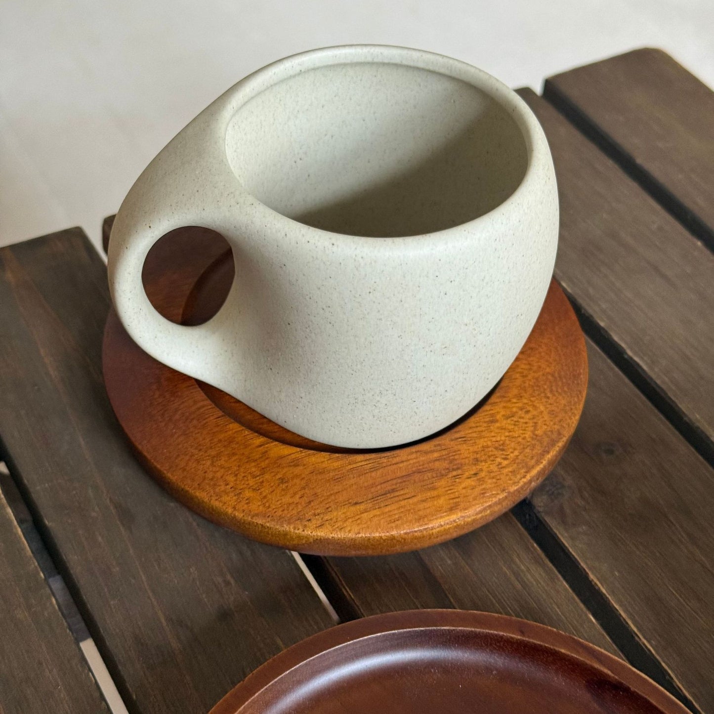 A ceramic coffee cup wooden saucer set